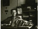 Fotografia: Czesław Świderski w mundurze porucznika (siedzi za biurkiem z książkami).