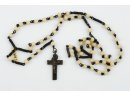 Różaniec o ebonitowych paciorkach, zakończony owalnym medalikiem, z wizerunkiem Chrystusa w awersie oraz symbolem eucharystycznym w rewersie